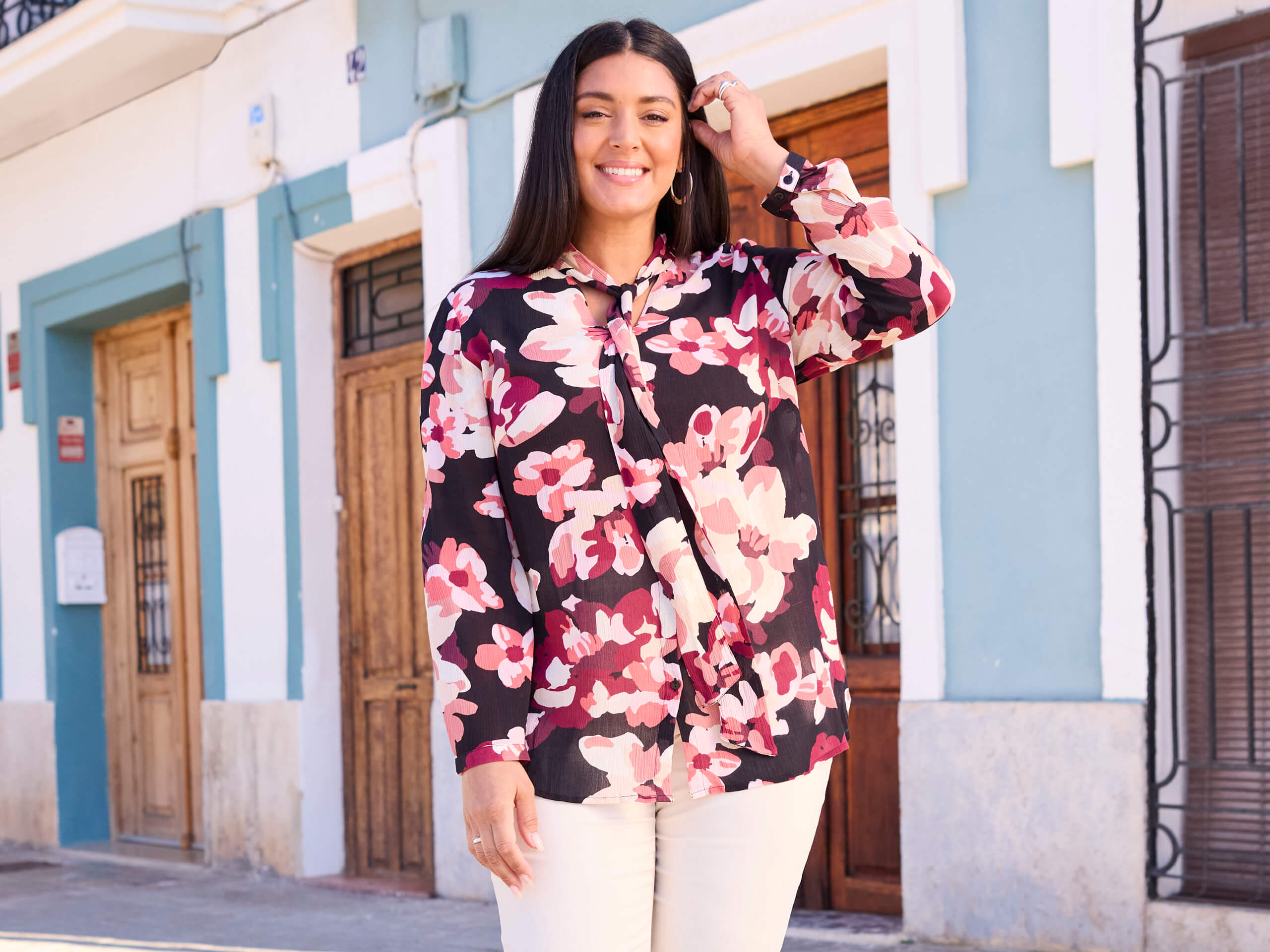 Werbebanner mit Model in großformatig geblümter Bluse und weißer Hose