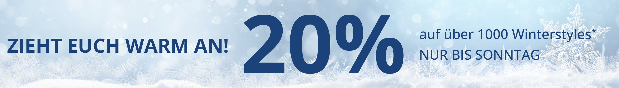 Model in Kuschelpullover in Blautönen vor winterlicher Landschaft