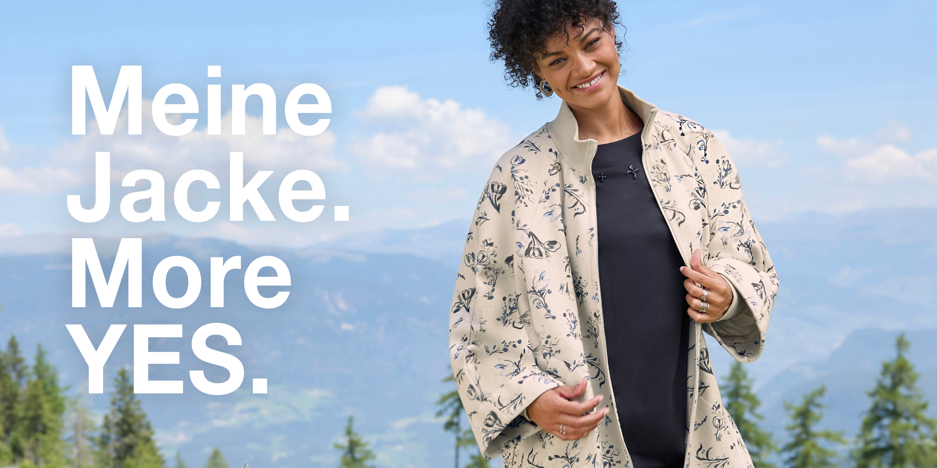 Werbebanner mit lächelndem Model in sandfarbener Sweatjacke mit blauem floralen Muster und Text: Meine Jacke. More Yes.