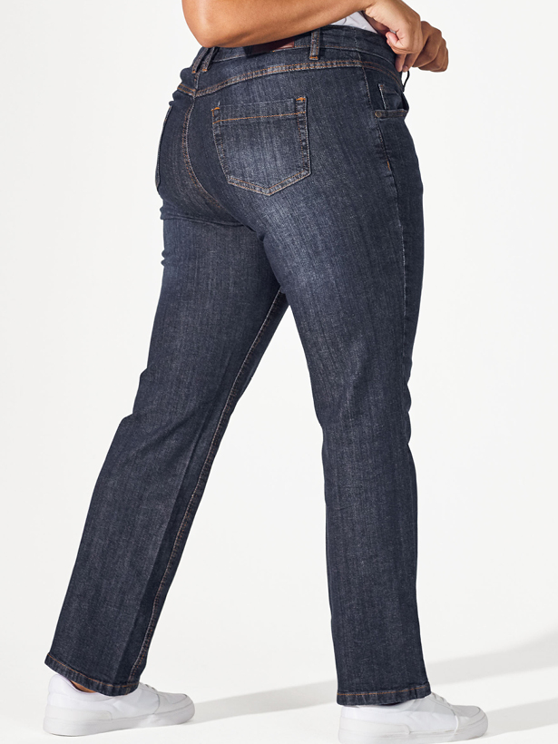 Frau steht seitlich und zeigt ihre gerade Jeans