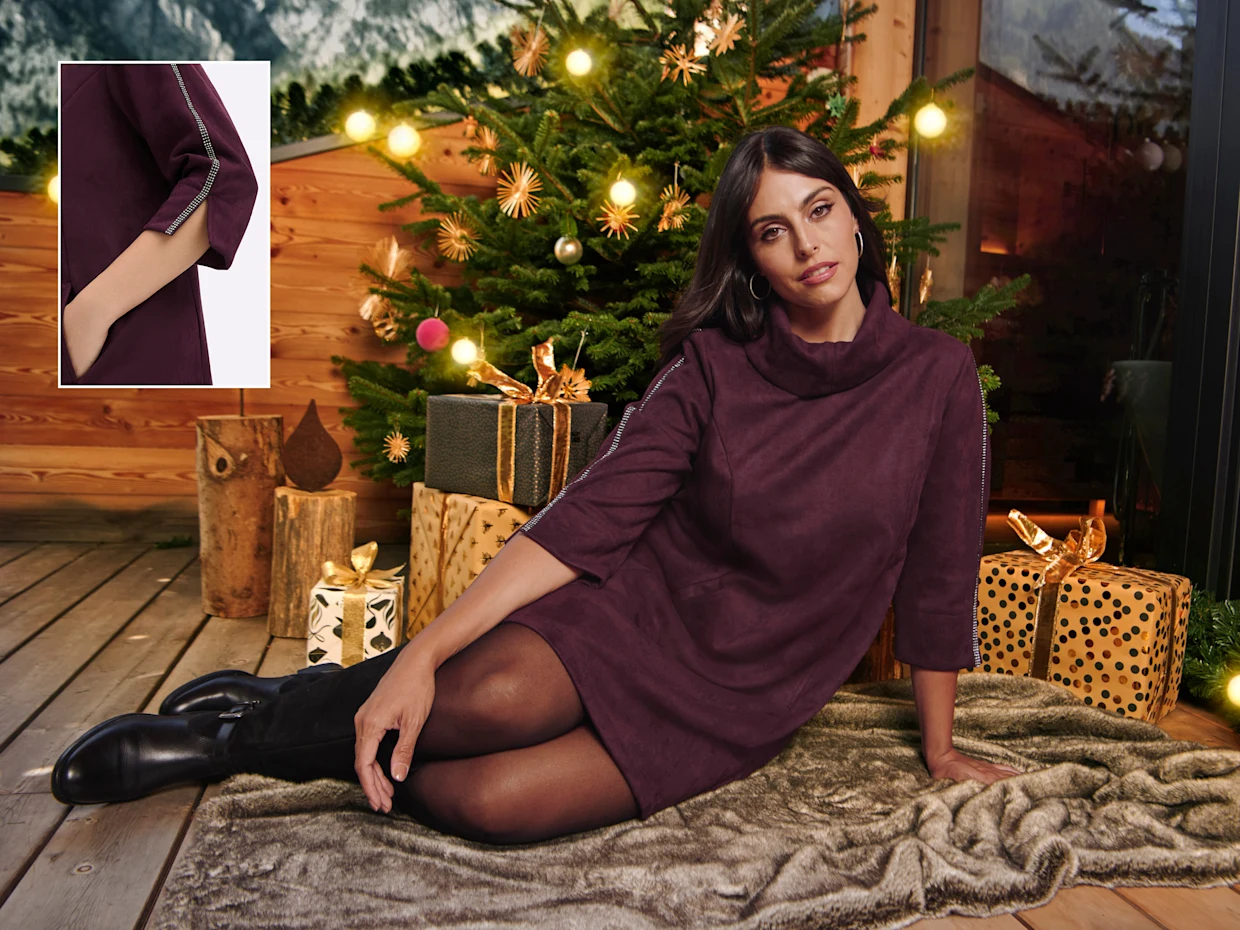 Ein Model in einer weihnachtlich geschmückten Umgebung. Sie trägt ein bordeauxfarbiges Kleid aus Verloursleder-Imitat mit Glitzersteinchen. Daneben befindet sich in vergrößerter Abbildung der geschlitzte Armabschluß des Kleides.