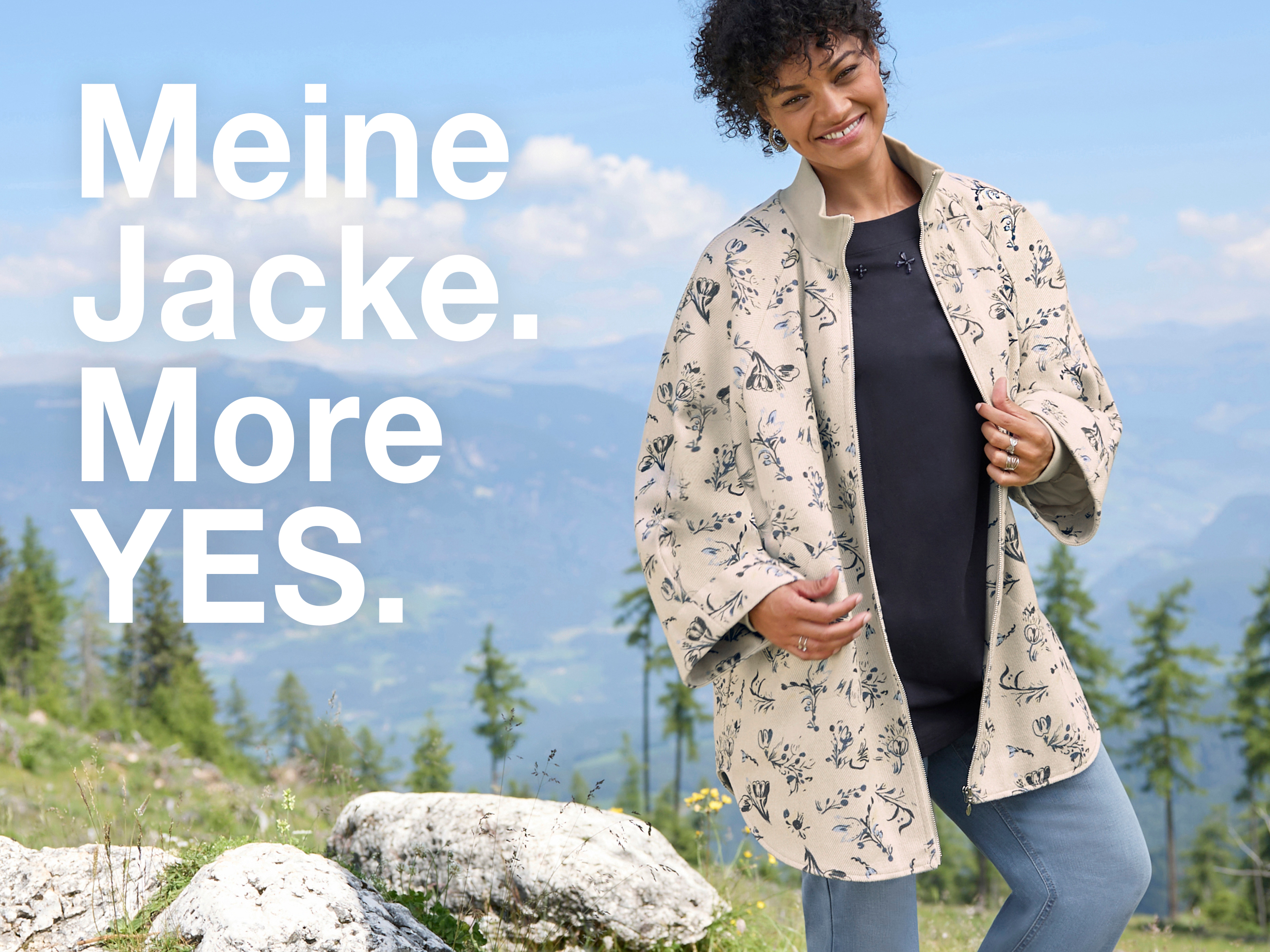 Ein Model trägt eine champagner-rauchblau-gemusterte Cape-Jacke, ein tiefblaues Shirt und blue-bleached Jeans. Daneben folgender Text: Meine Jacke. MORE YES.