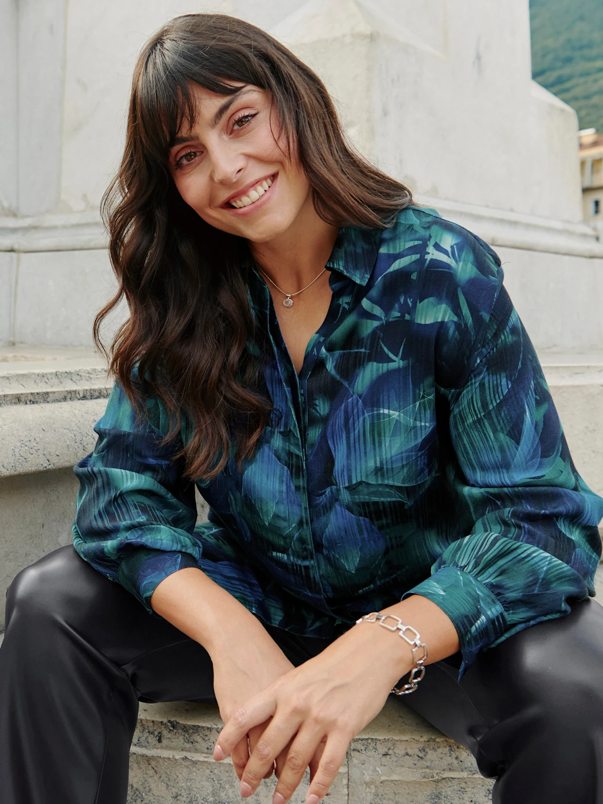Model in türkis-dunkelblau bedruckter Bluse