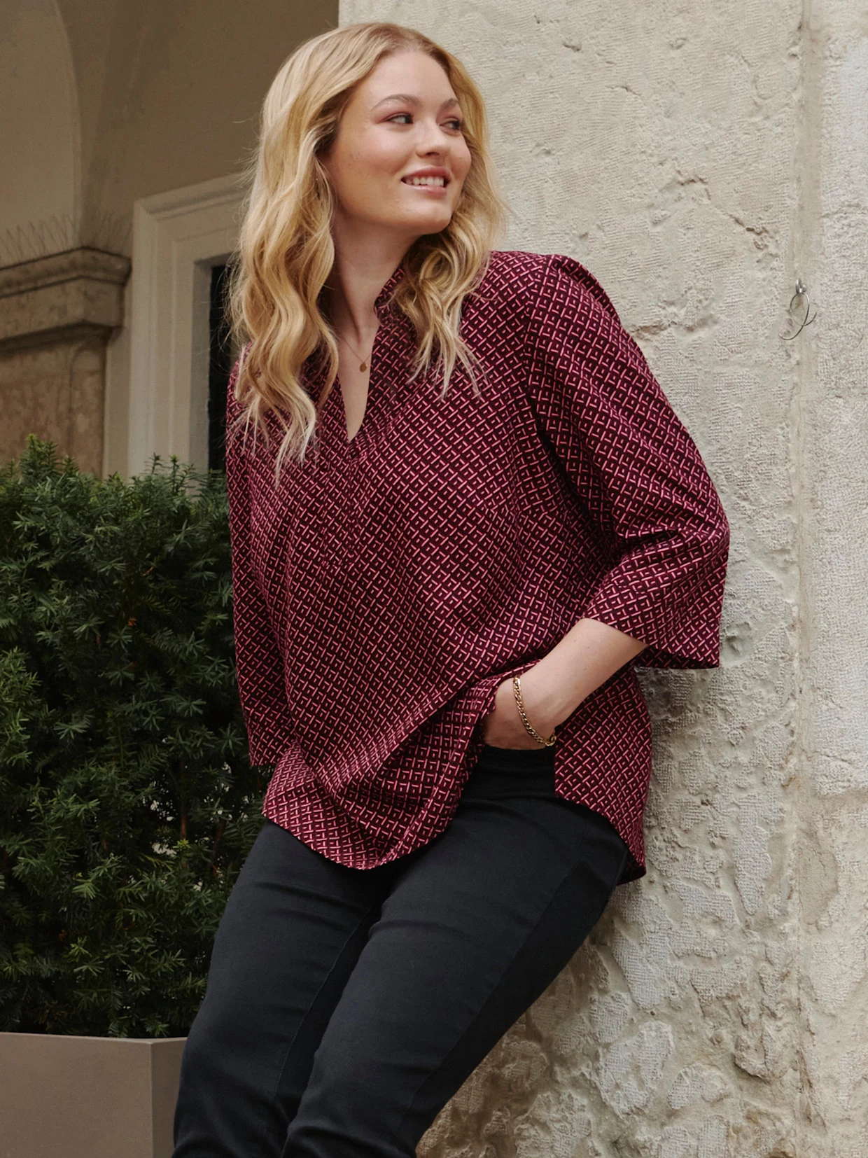 Model in bordeauxfarbener Tunika mit geometrischem Minimalprint