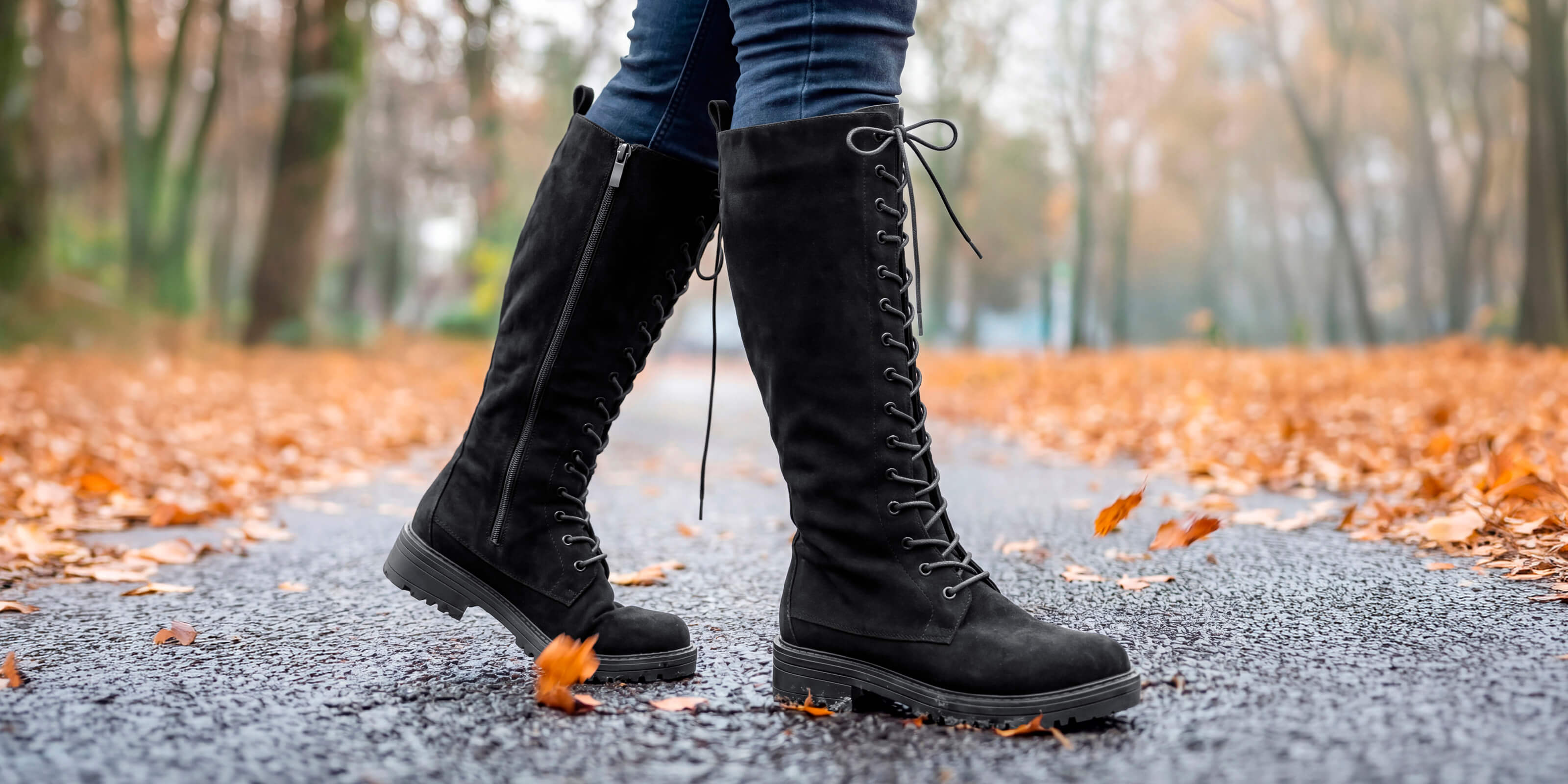 Die Abbildung zeigt schwarze Schnürstiefel in Wildleder-Optik in herbstlicher Umgebung