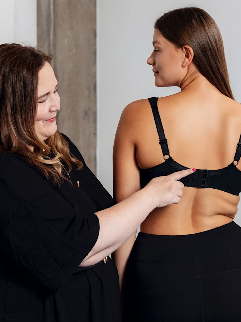 Frau berät andere Frau mit einem BH