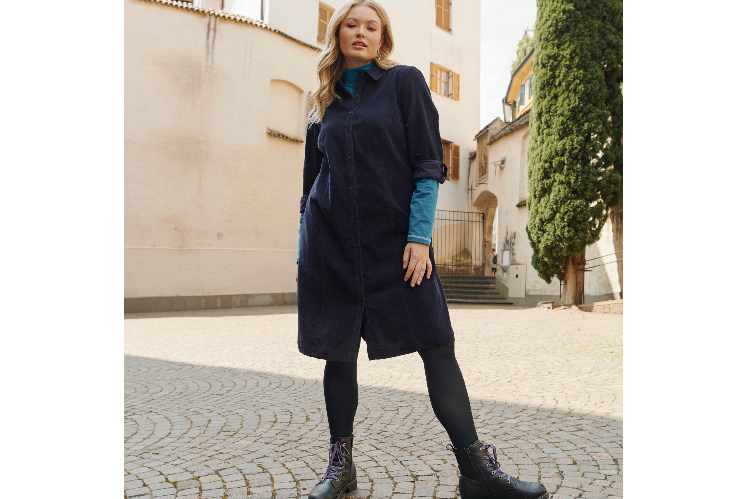 Model mit marinefarbenem Feincordkleid über Türkise Langarmrolli