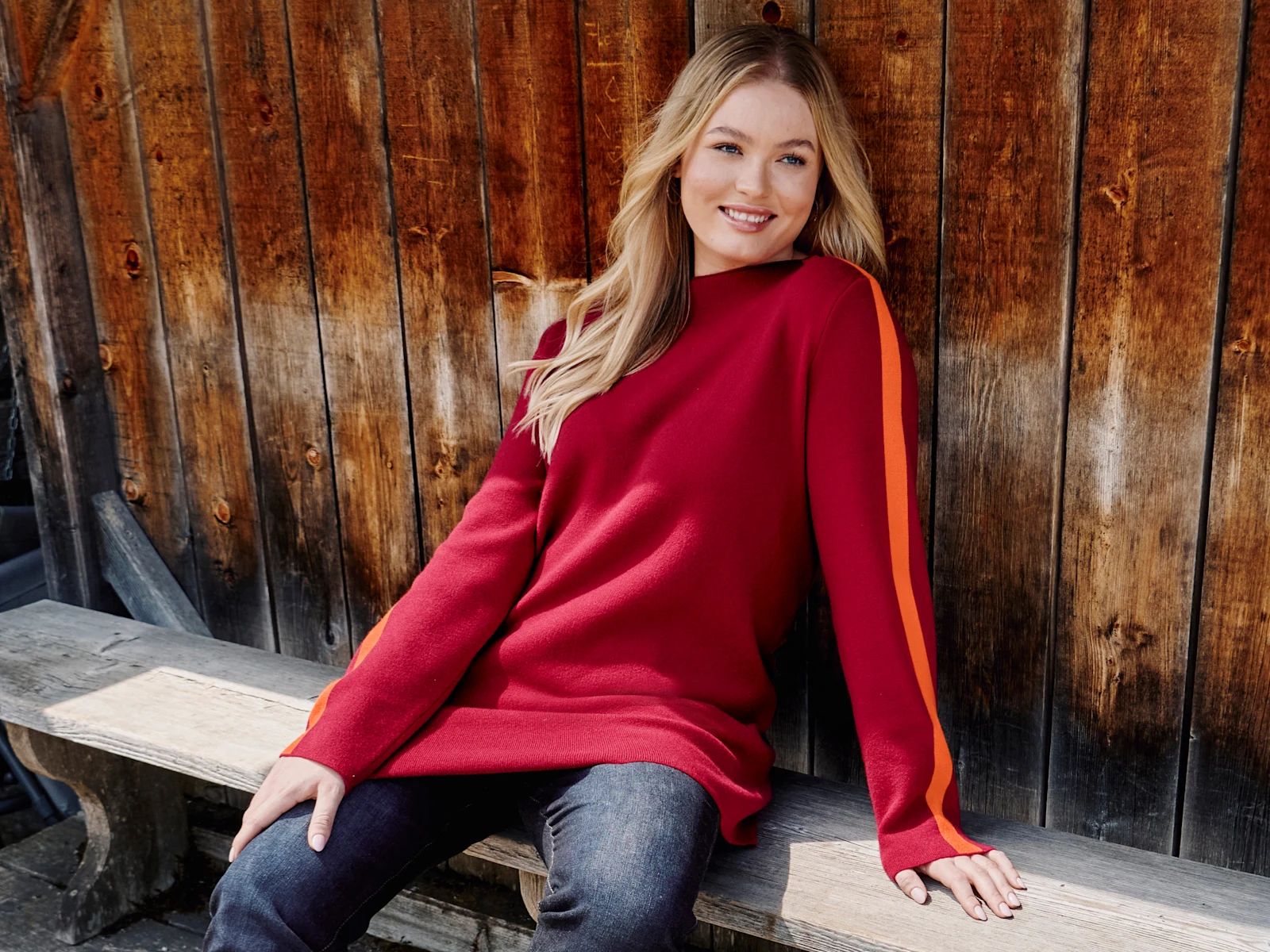 Model mit kirschrotem Pulli mit orangem Streifen am Ärmel Model mit kirschrotem Pulli mit orangem Streifen am Ärmel