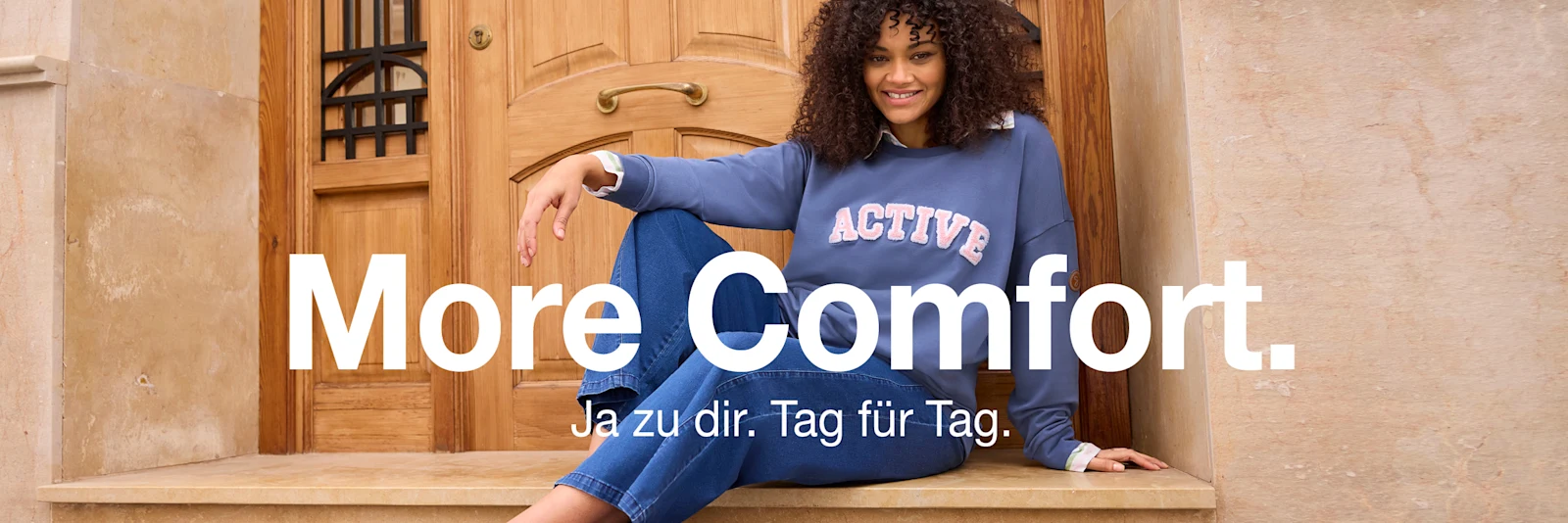 Werbebanner mit Model in Sweatshirt und Jeans mit Text: More Comfort. Ja zu dir. Tag für Tag. Werbebanner mit Model in Sweatshirt und Jeans mit Text: More Comfort. Ja zu dir. Tag für Tag.
