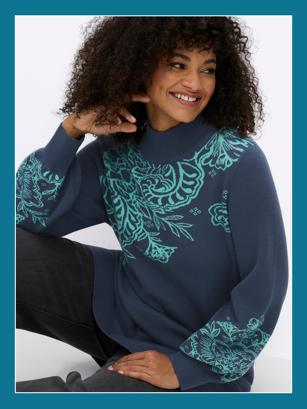 Ein Model trägt einen blau-türkisen einen Longpullover mit Paisleymuster und Ballonärmeln