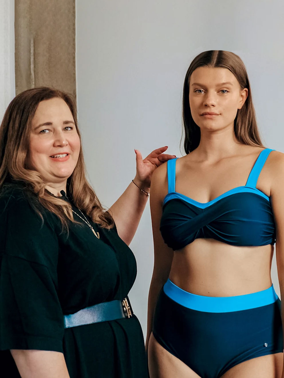 eine Frau berät eine andere Frau mit Bademode