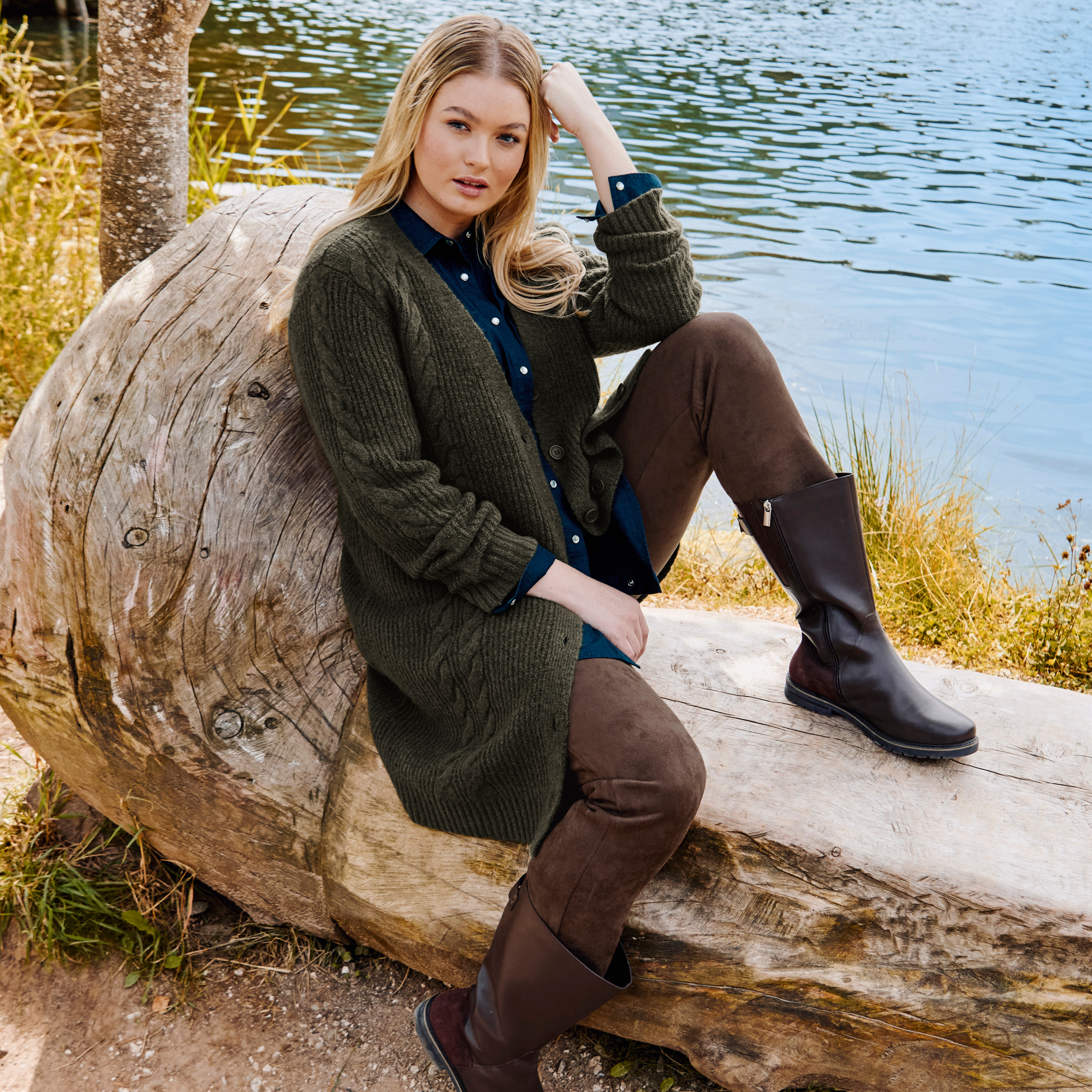 Model mit dunkelgrüner Strickjacke über Jeansbluse und brauner schmaler Samthose