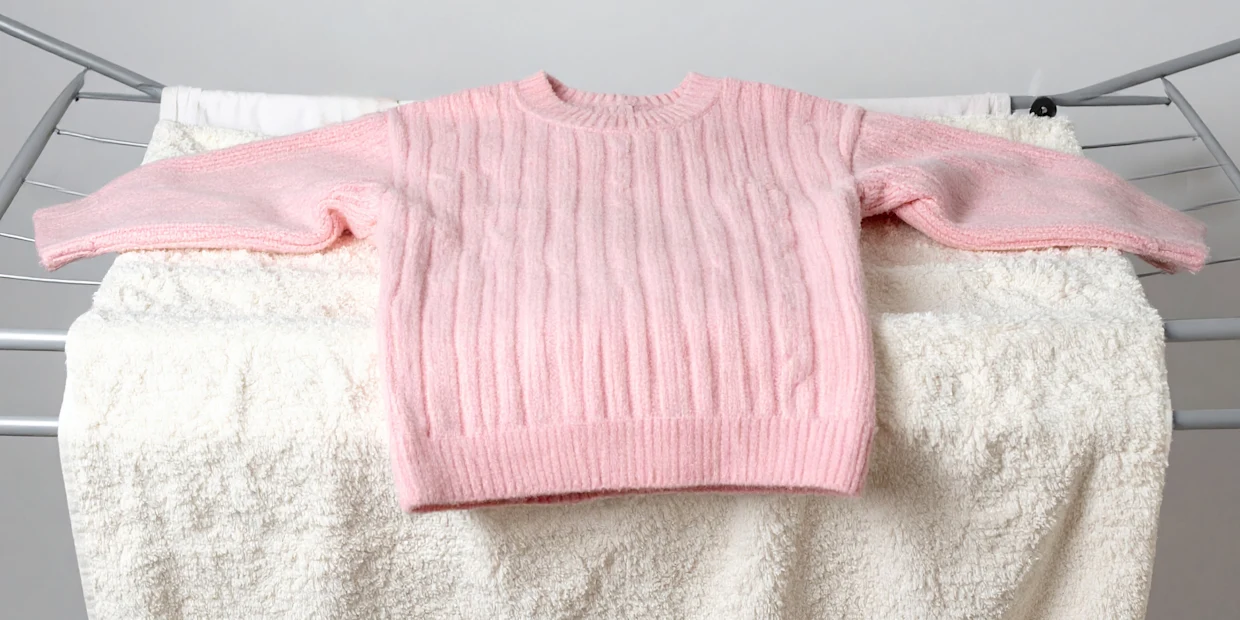 Ein Strickpullover, der zum Trocknen flach ausgebreitet wurde Ein Strickpullover, der zum Trocknen flach ausgebreitet wurde