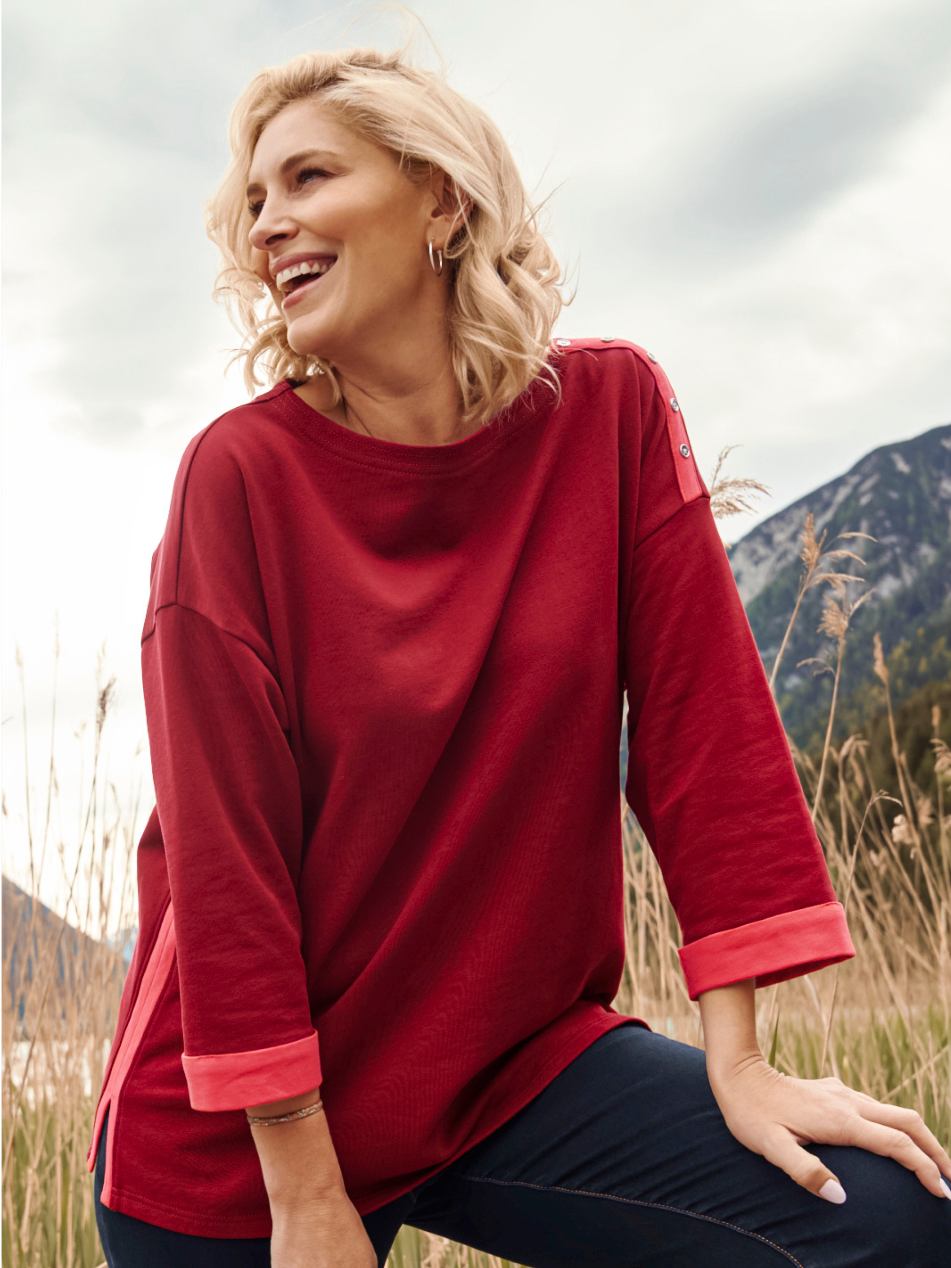 Model mit rotem Sweatshirt mit orangefarbenen Paspeln