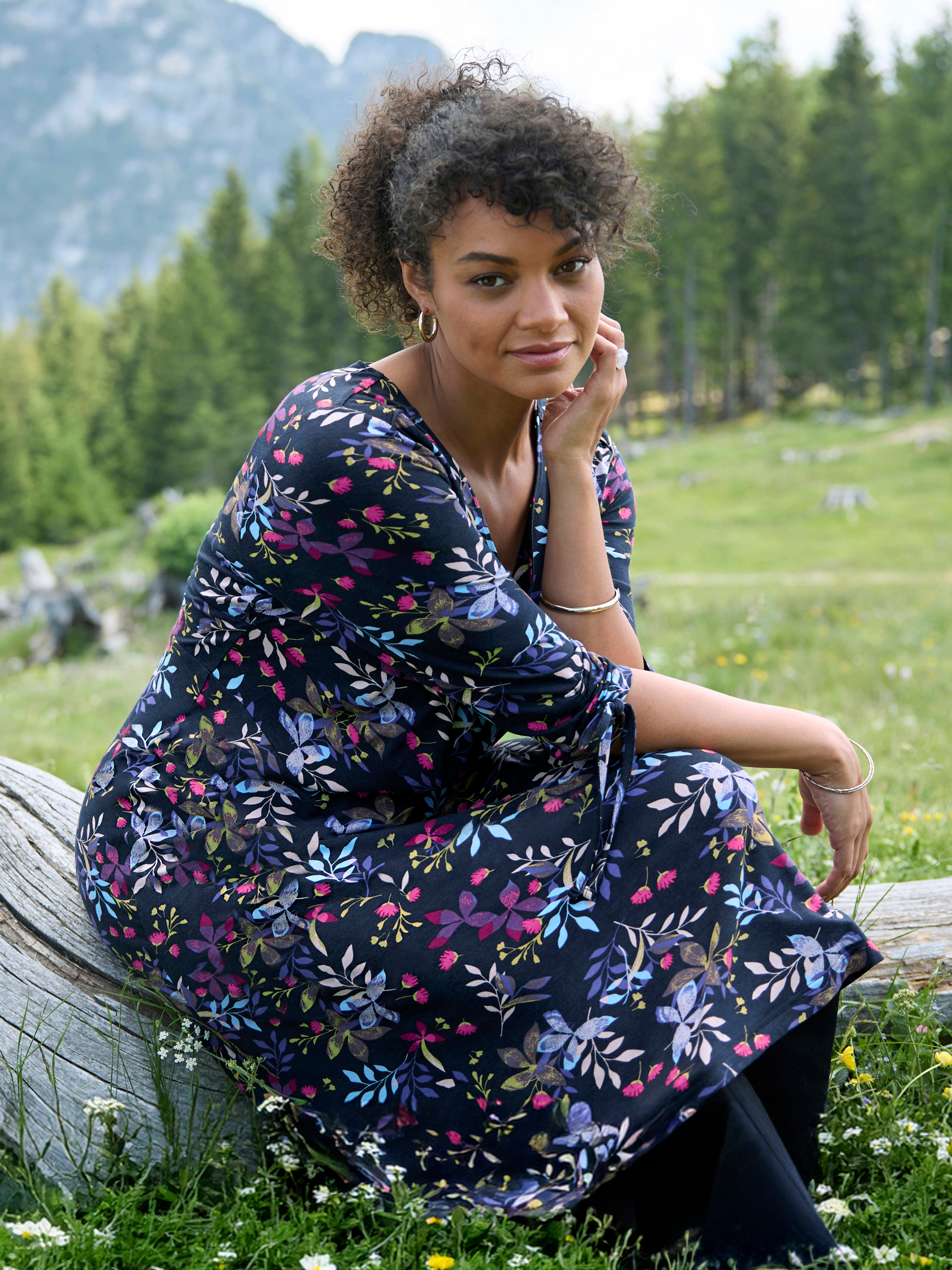 Werbebanner mit Model in herbstlich gemustertem Kleid in türkis, lila und pink auf Schwarz