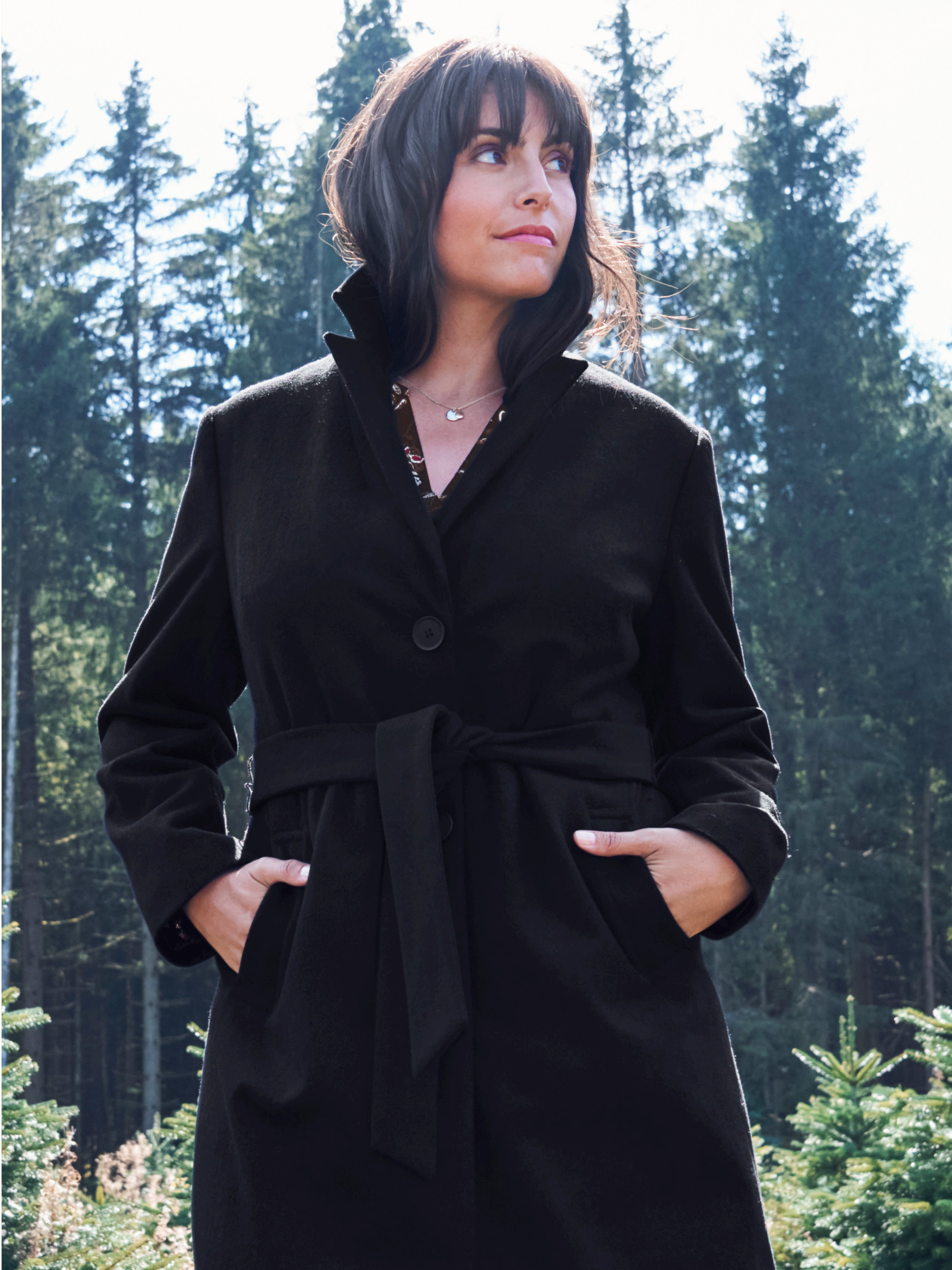 Model mit schwarzem Mantel in Wolloptik