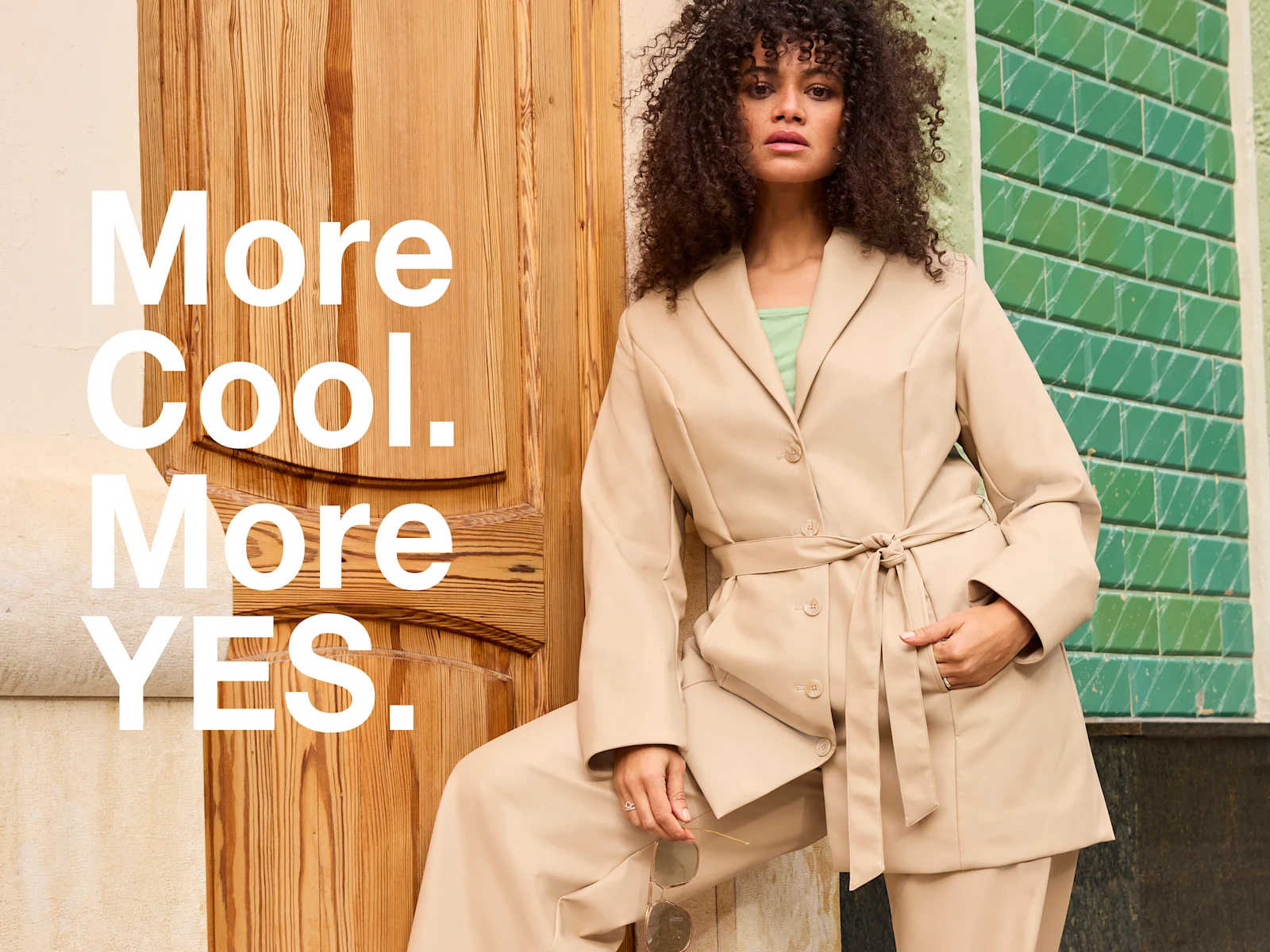 Werbebanner mit Model mit sandfarbenem Trenchcoat und Text: More Cool. More YES.