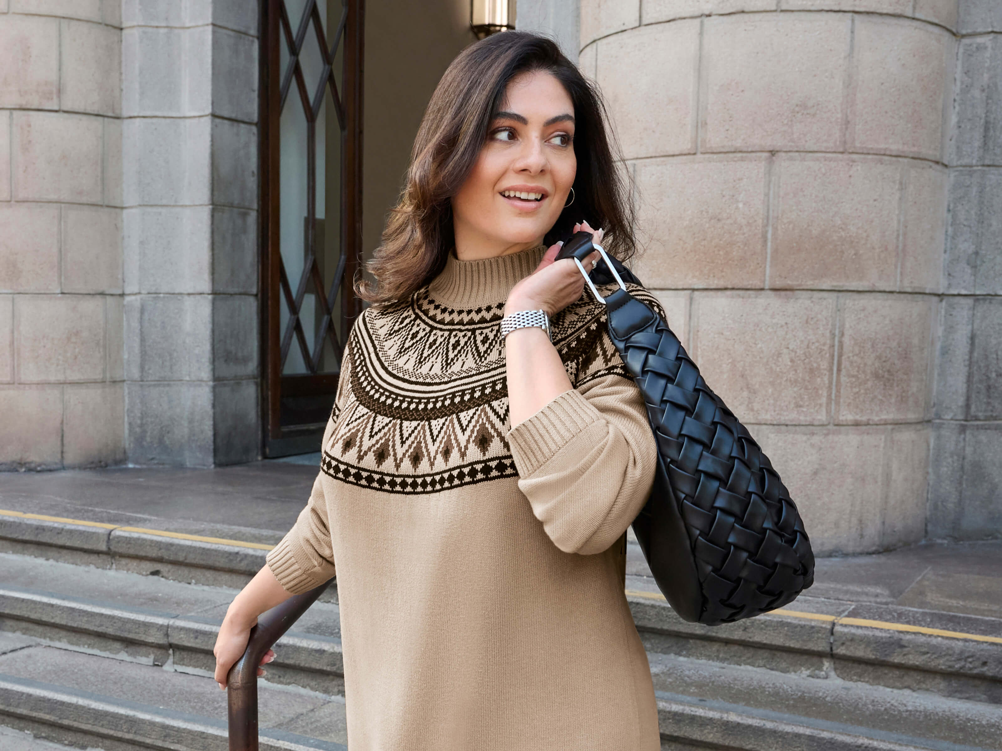 Ein Model trägt einen beige-schoko-gemusterten Jacquardpullover im Norweger-Stil