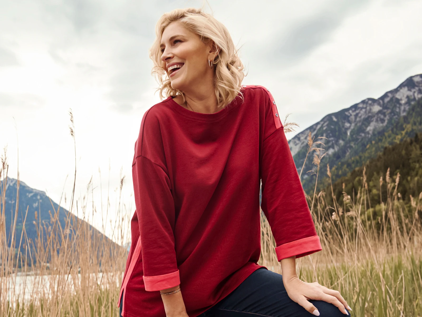 Model mit rotem Sweatshirt mit orangefarbenen Paspeln