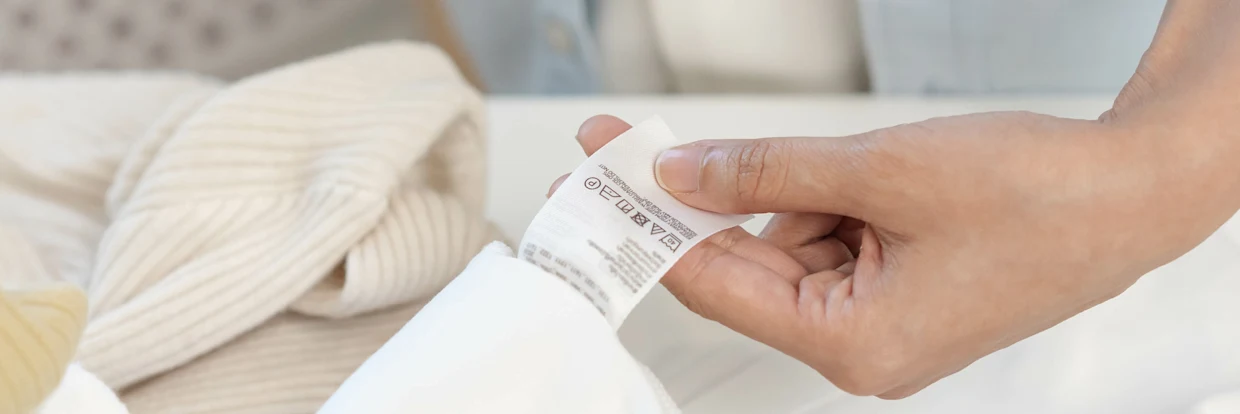 Detailaufnahme eines Stoffes mit Pflegeetikett Detailaufnahme eines Stoffes mit Pflegeetikett