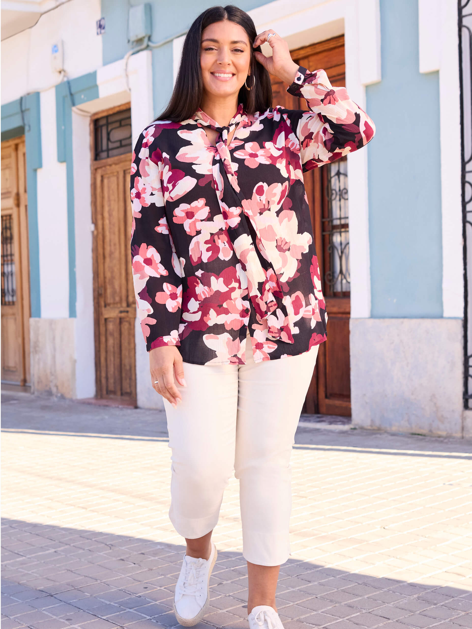 Werbebanner mit Model in großformatig geblümter Bluse und weißer Hose