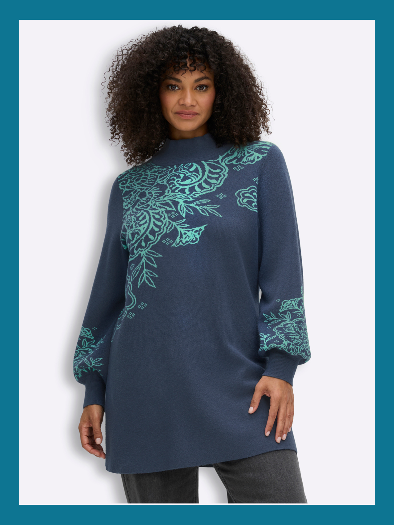 Ein Model trägt einen blau-türkisen einen Longpullover mit Paisleymuster und Ballonärmeln