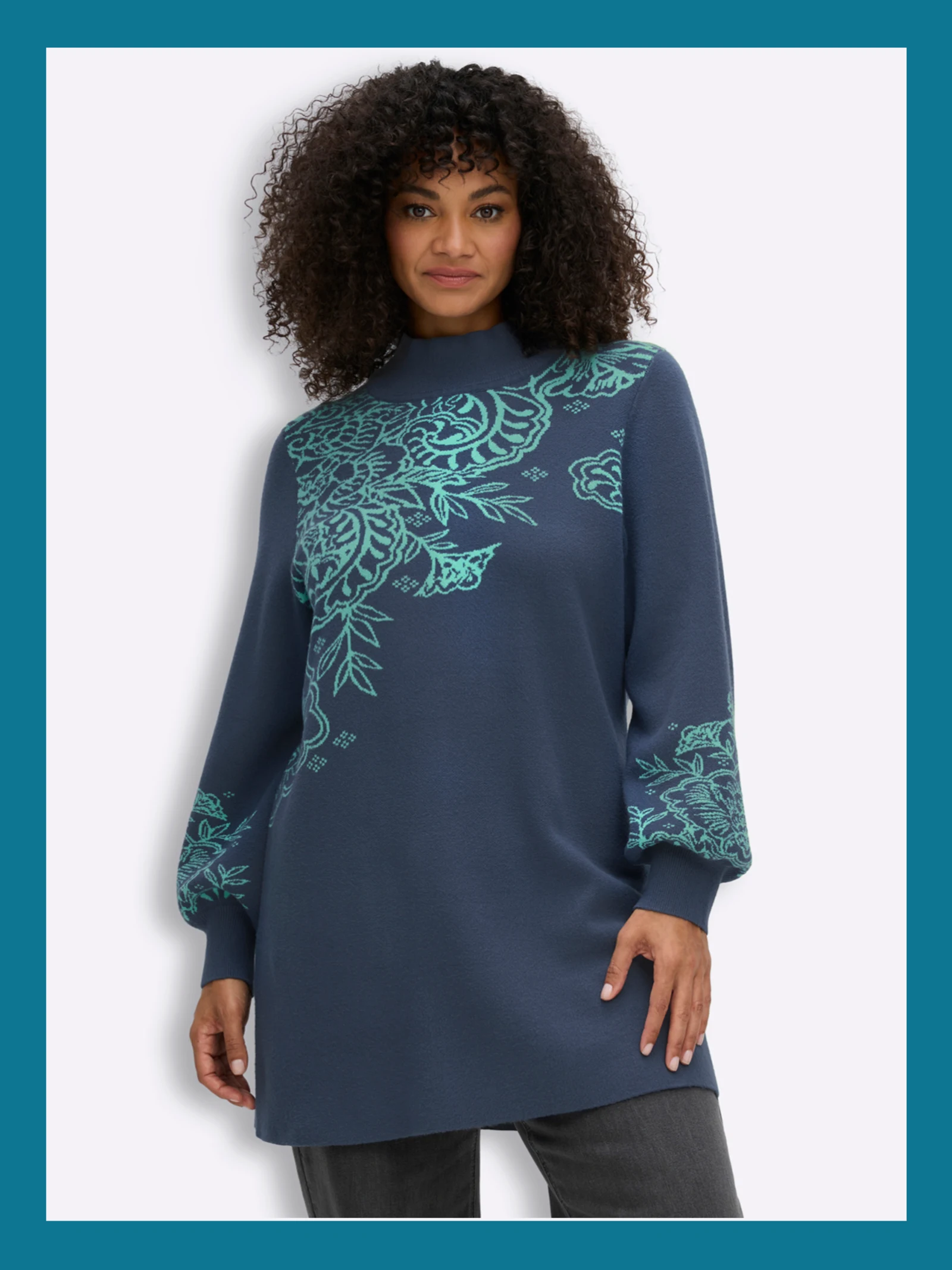 Ein Model trägt einen blau-türkisen einen Longpullover mit Paisleymuster und Ballonärmeln