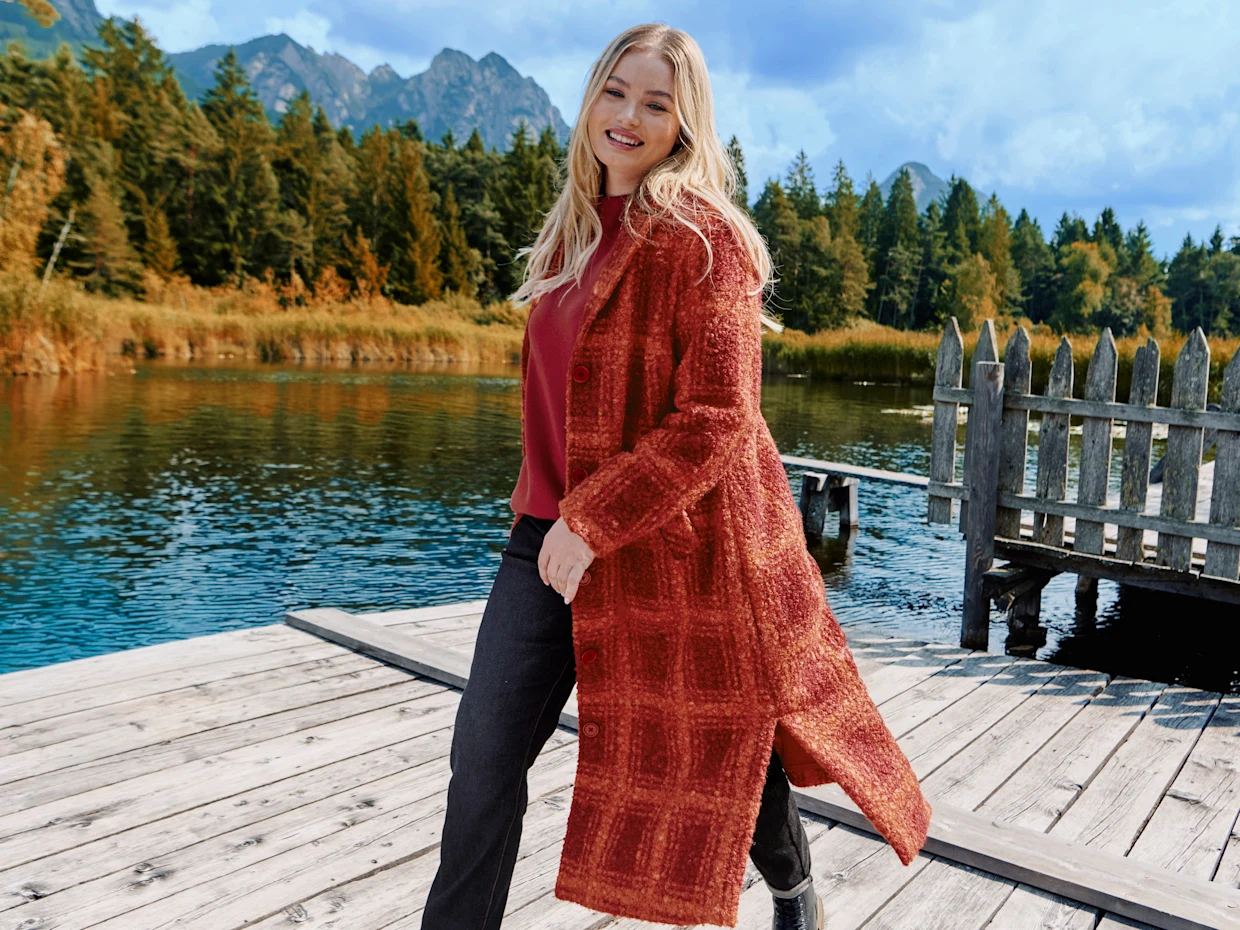 Model mit orange-rot kariertem Mantel in Wolloptik