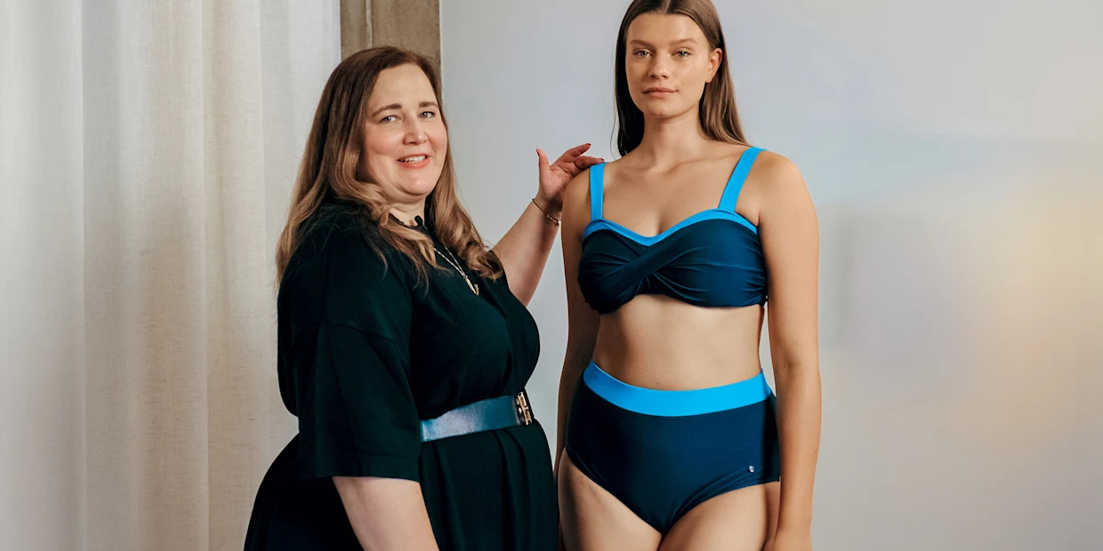 Bademoden Beratungsbild mit Beratungs-Fachfrau sheego und Model mit blau-türkisfarbenem Bikini Bademoden Beratungsbild mit Beratungs-Fachfrau sheego und Model mit blau-türkisfarbenem Bikini