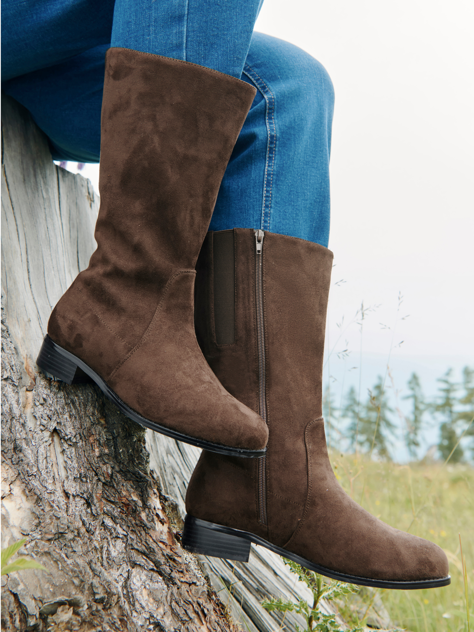 Ein Model trägt blaue Jeans und braune Weitschaftstiefel