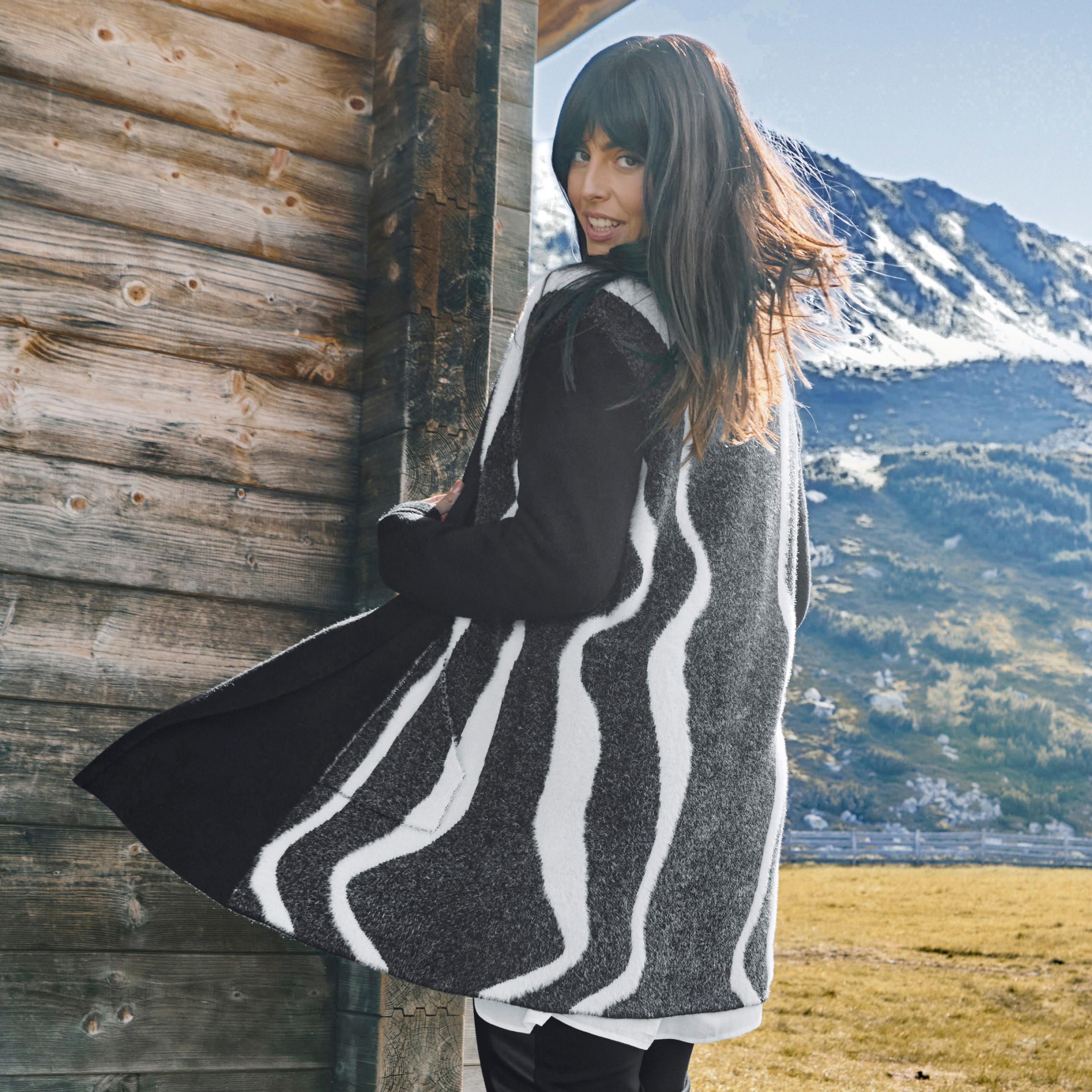 Model in schwarzem Cardigan mit weißen gewellten Streifen