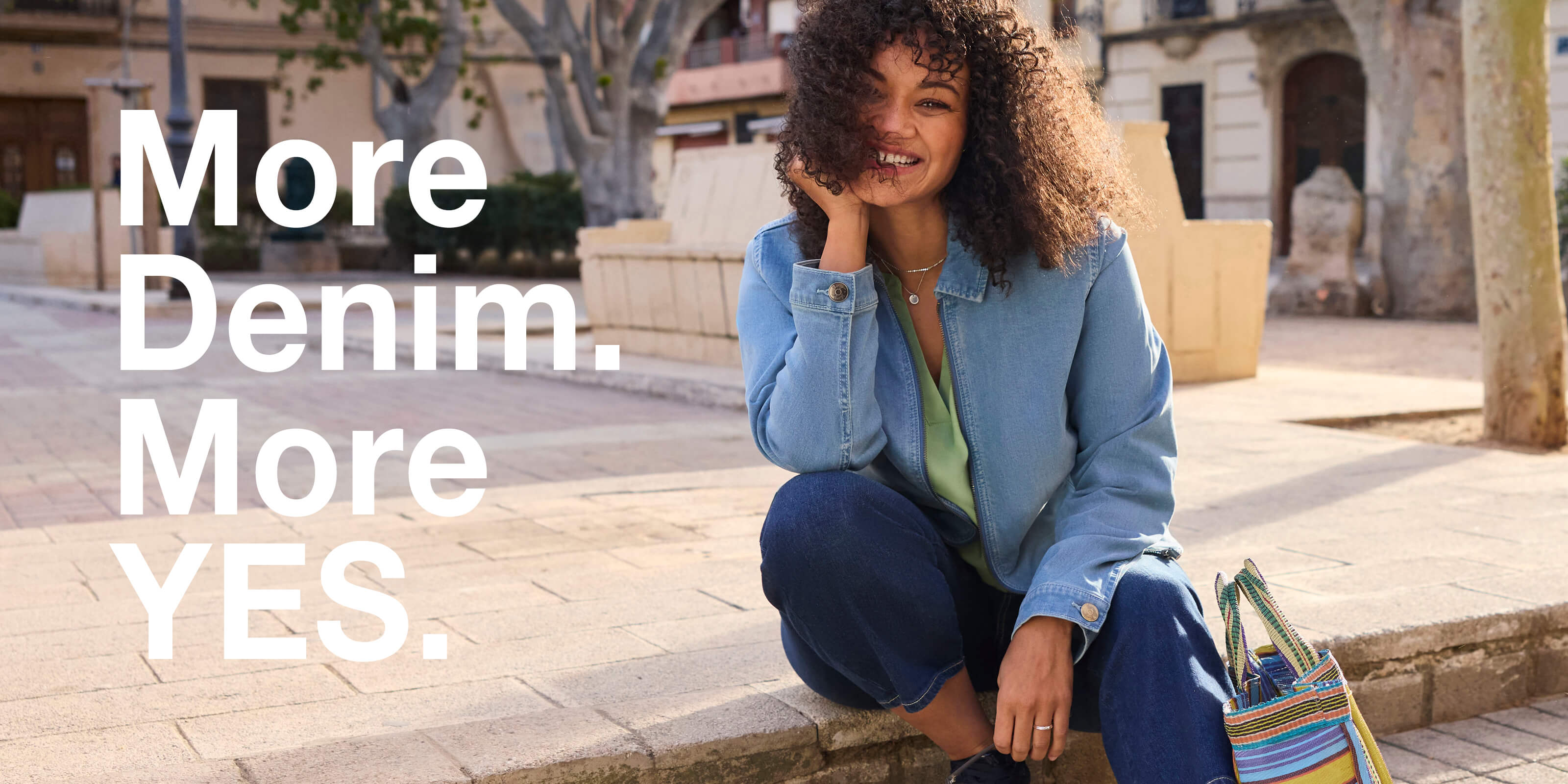 Ein Model trägt eine Jeansjacke in light blue und eine Jeans in dark-blue. Daneben der Text: More Denim. More yes.