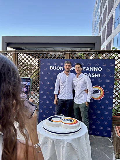 due dipendenti P&G Italia posano di fronte alla torta celebrativa di Dash60