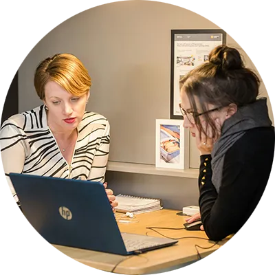Due persone in azienda si scambiano conoscenze utili in un processo di mentoring e reverse mentoring.