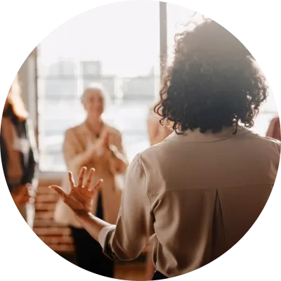 Una donna in piedi di fronte ad altre a rappresentare l’empowerment femminile in un contesto aziendale.