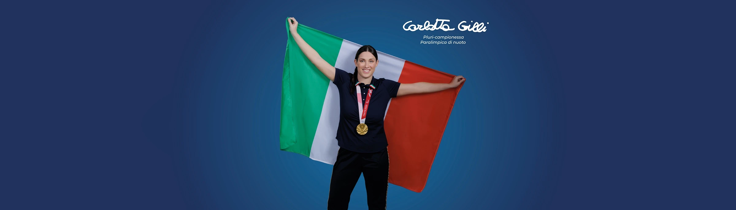 Carlotta Gilli pluricampionessa paralimpica di nuoto tiene tra le braccia la bandiera italiana