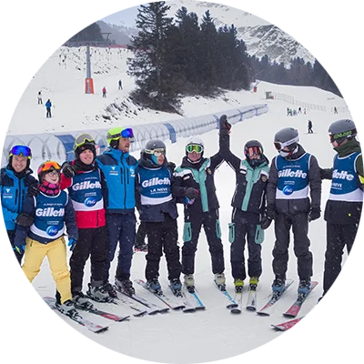 Un gruppo di giovani con disabilità e istruttori specializzati durante una lezione di sci.