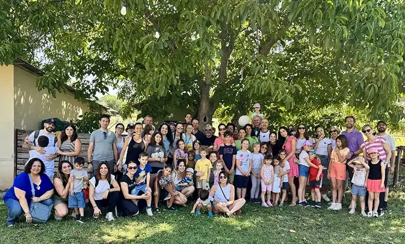  un ampio gruppo di dipendenti di P&G Italia composto da 47 bambini e dai loro genitori in posa sotto a un castagno secolare presso la Cooperativa Capodarco di Grottaferrata (RM).