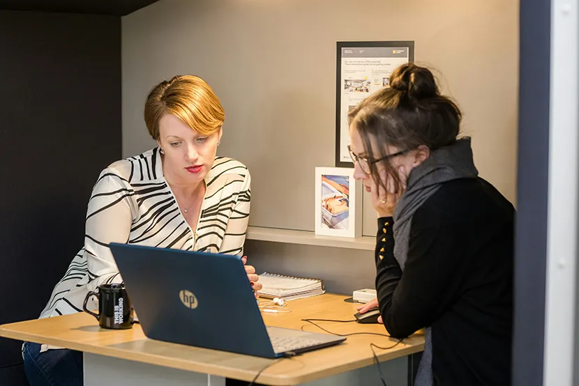 Due persone in azienda si scambiano conoscenze utili in un processo di mentoring e reverse mentoring.