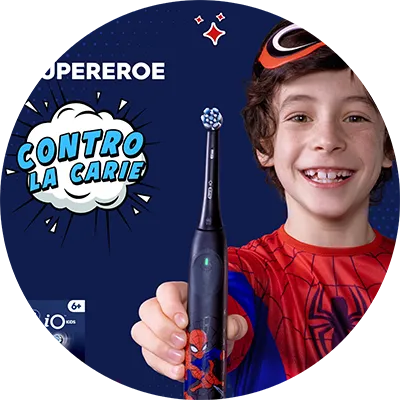 oralb io kids il super eroe contro le carie. Un bambino con una macheda di spiderman poggiata sui capelli indossa una maglietta di spiderman e sorride mostrando il suo oral b io kids di spiderman. 