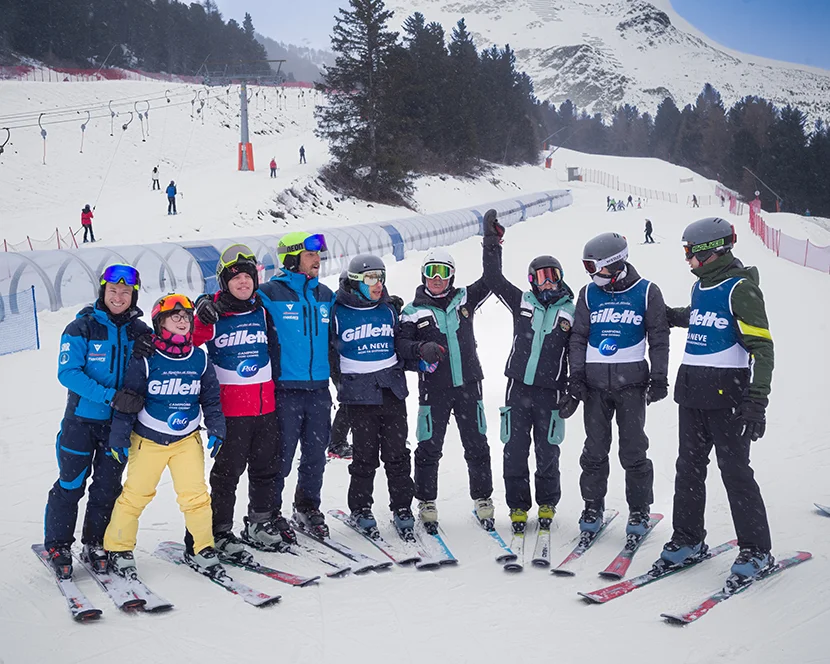 Un gruppo di giovani con disabilità e istruttori specializzati durante una lezione di sci.