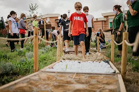 Bambini camminano scalzi su diverse superifici naturali