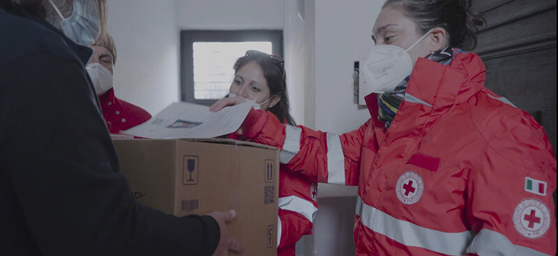 Carlotta Gilli consegna dei pacchi di prodotti con la Croce Rossa Italiana