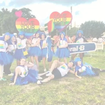 Donne in posa con accessori rainbow e il logo di OralB in vista