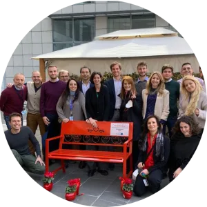 Un gruppo di donne accanto alla panchina rossa di una sede P&G 