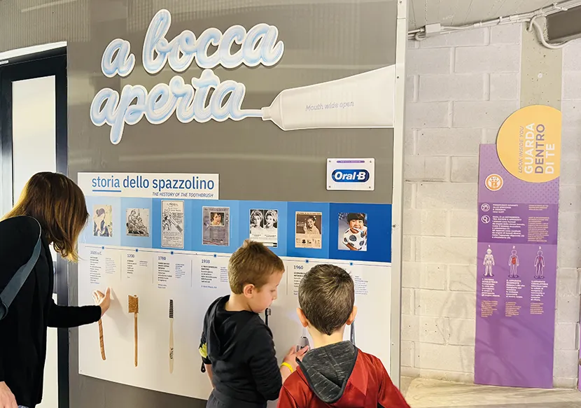 Due bambini davanti all’esposizione sulla storia dello spazzolino durante la mostra “A bocca aperta” realizzata da Explora e Oral-B dedicata all’igiene orale.