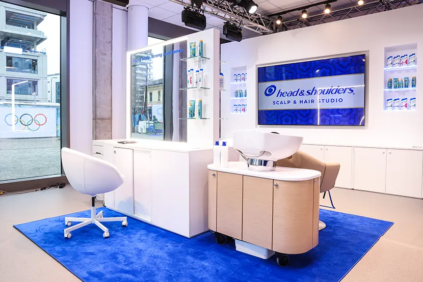 lo spazio allestito da Head & Shoulders per offrire agli atleti del Villaggio Olimpico di Milano analisi del cuoio capelluto e servizi di hairstyle. Presenti due postazioni con lavabo e maxi schermi che riportano il logo Head & Shoulders.