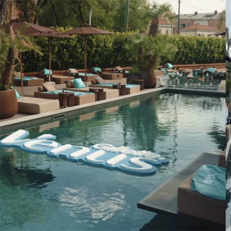 Una piscina con il logo di Gillette Venus flottante sull’acqua. Attorno un solarium dalle tonalità beige con cuscini color acquamarina con la scritta Venus Glow Fest.