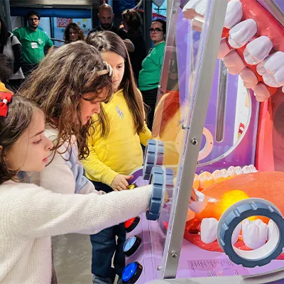 Due bambine giocano con la bocca gigante, toccandone la lingua.