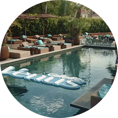 Una piscina con il logo di Gillette Venus flottante sull’acqua. Attorno un solarium dalle tonalità beige con cuscini color acquamarina con la scritta Venus Glow Fest.